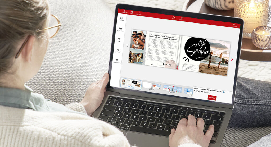 A person designs a CEWE photo book on a laptop.