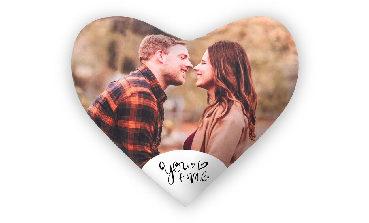 A couple kisses in a heart-shaped graphic, surrounded by warm colors and natural elements.