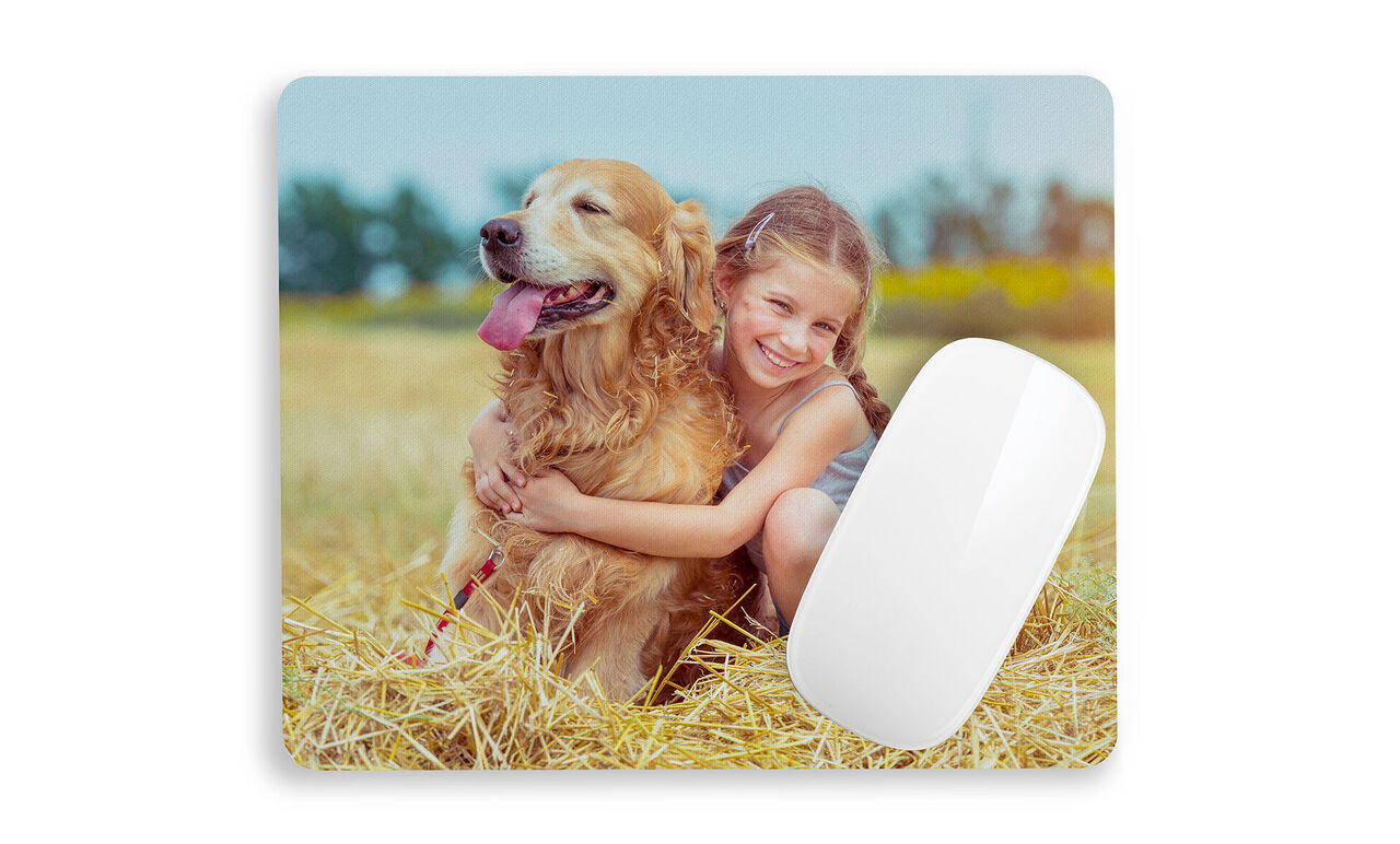 A girl hugs a golden retriever in a field.