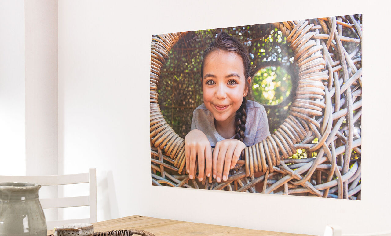 A child looks through a woven basket. It is in a bright room.