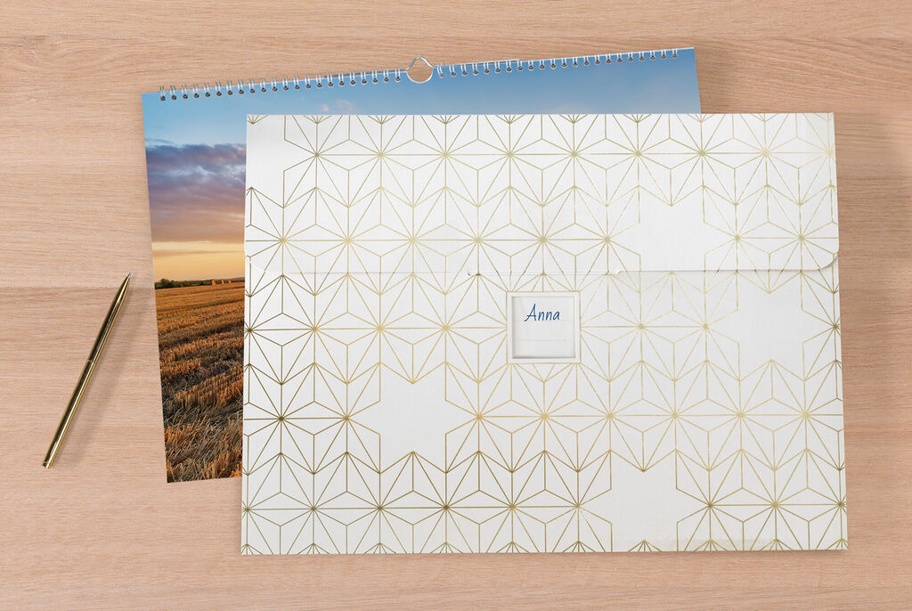 A stylish CEWE photo calendar with a modern golden geometric design and a small field for a name.