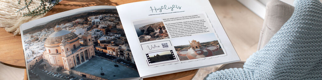 An open photo book on a table shows a large city view with small pictures