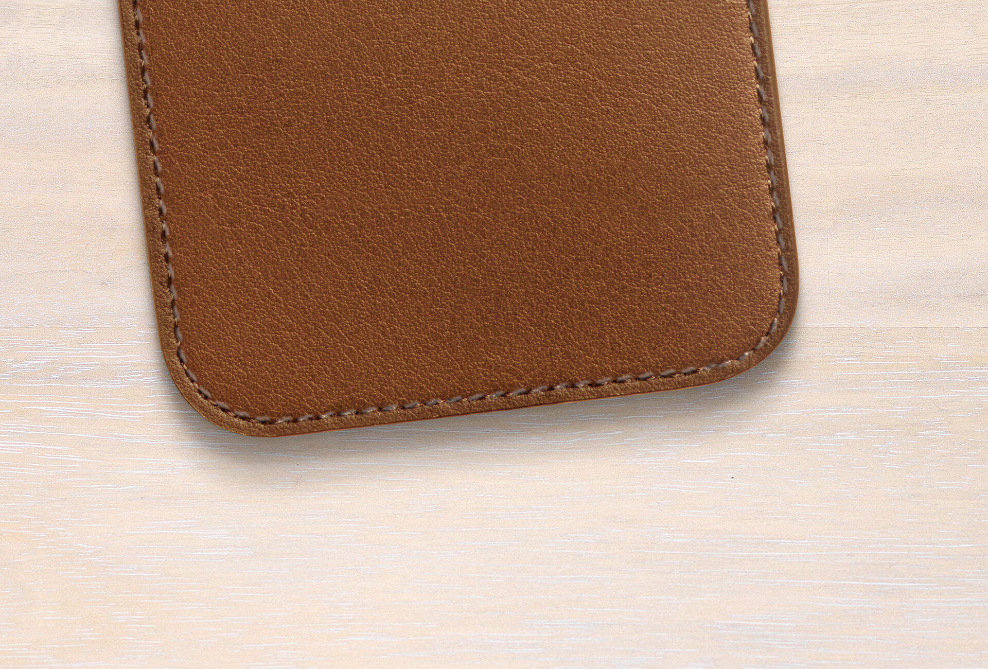 Brown leather case on a light wooden table.
