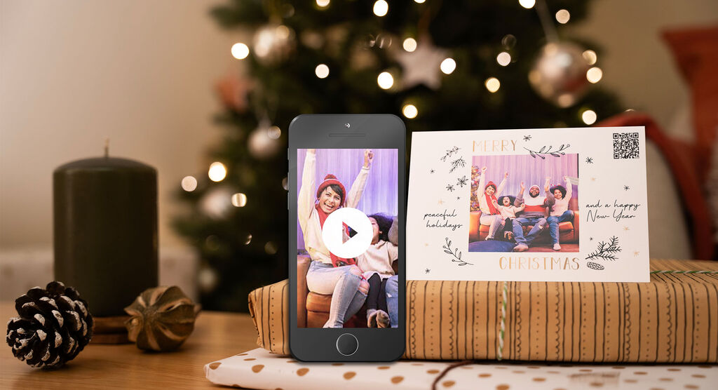 Merry Christmas: joy with friends in front of a Christmas tree, a card and a phone with video.