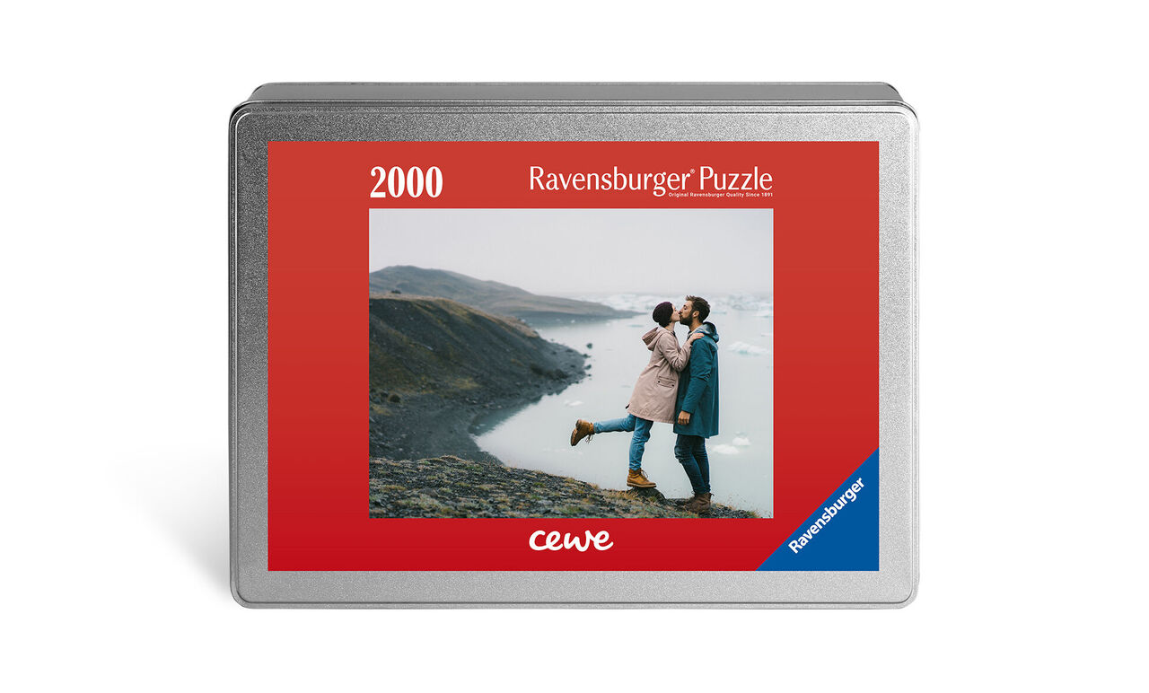 Couple embraces in front of a mountain landscape on a Ravensburger puzzle box by CEWE