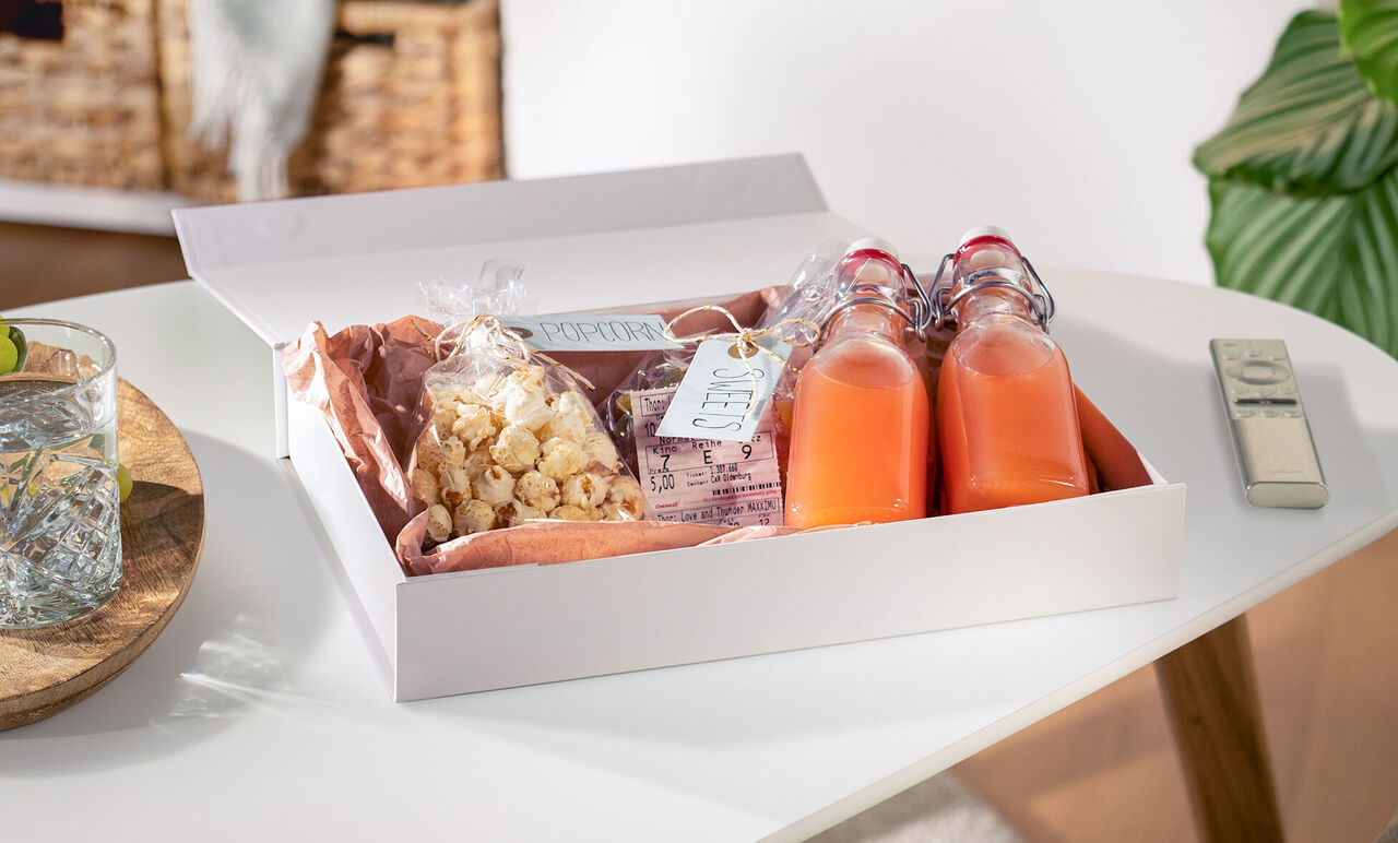 A lovingly arranged gift basket with snacks and drinks.