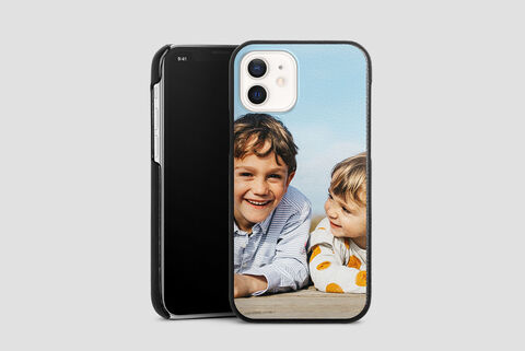 Two laughing children lying on a wooden bench enjoying the day.