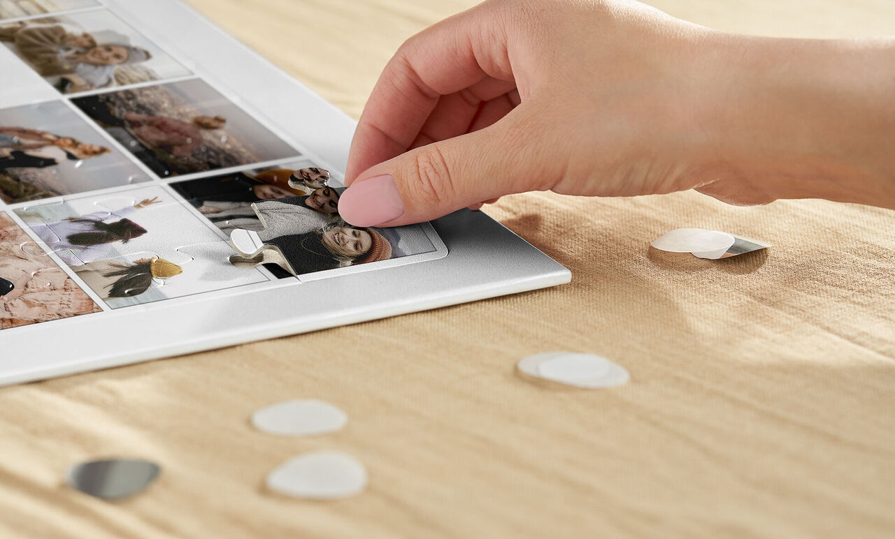 Little hands position graphic elements on a photo book