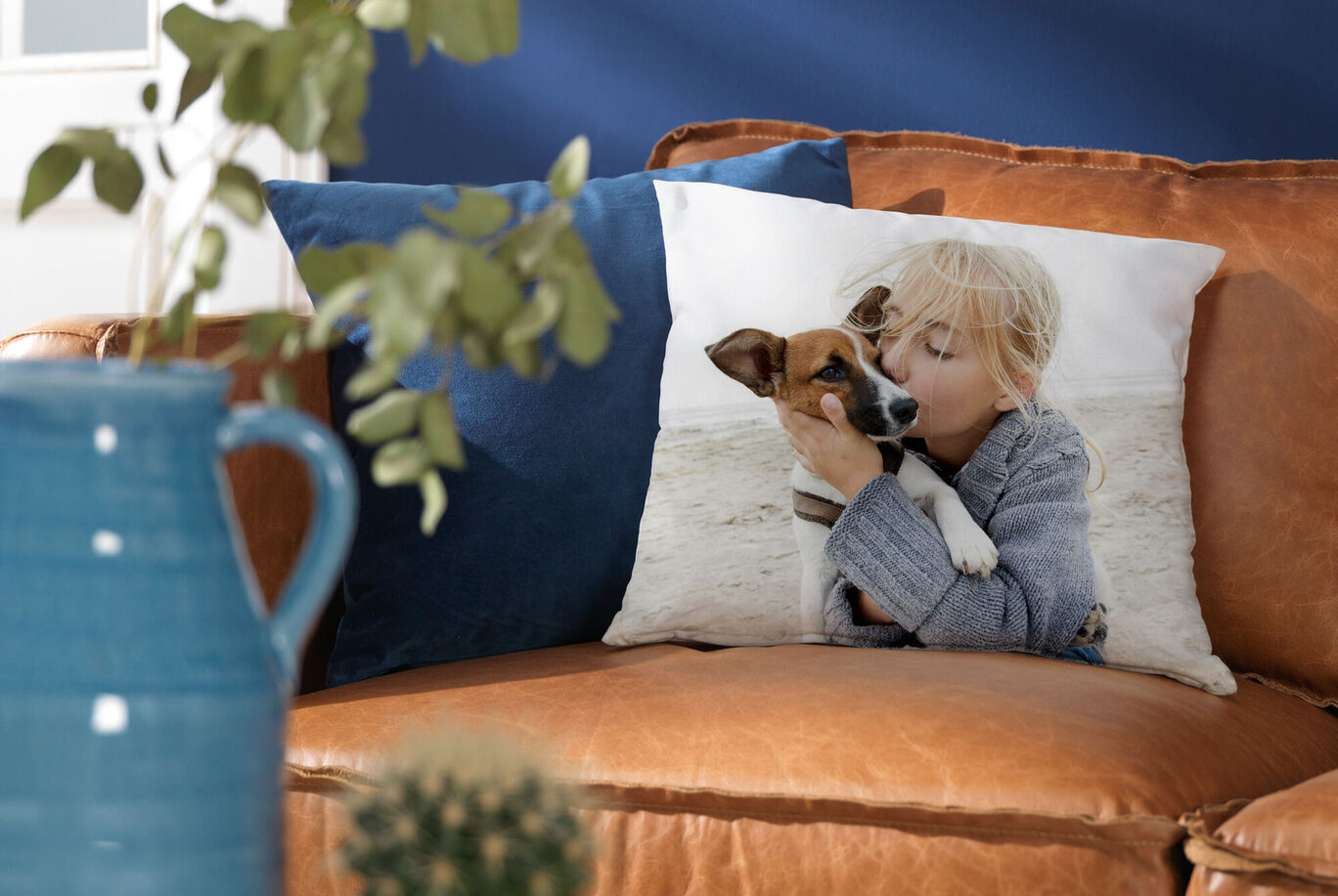 A lovingly designed pillow with an image of a child hugging a dog on a cozy sofa.