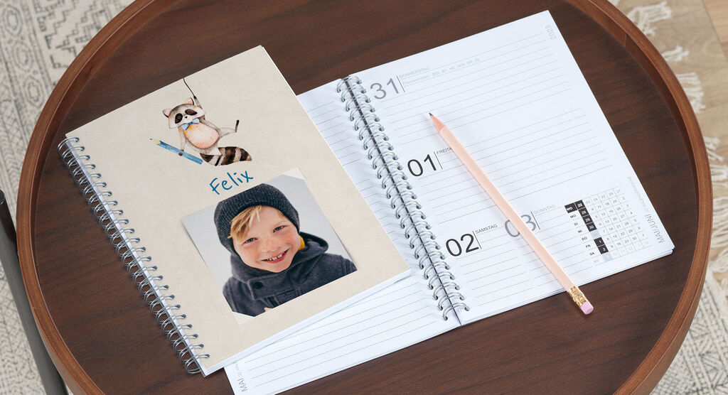 A table with a creative notebook and a calendar.