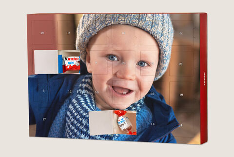 An advent calendar filled with chocolate, in the background a child with a cap smiles