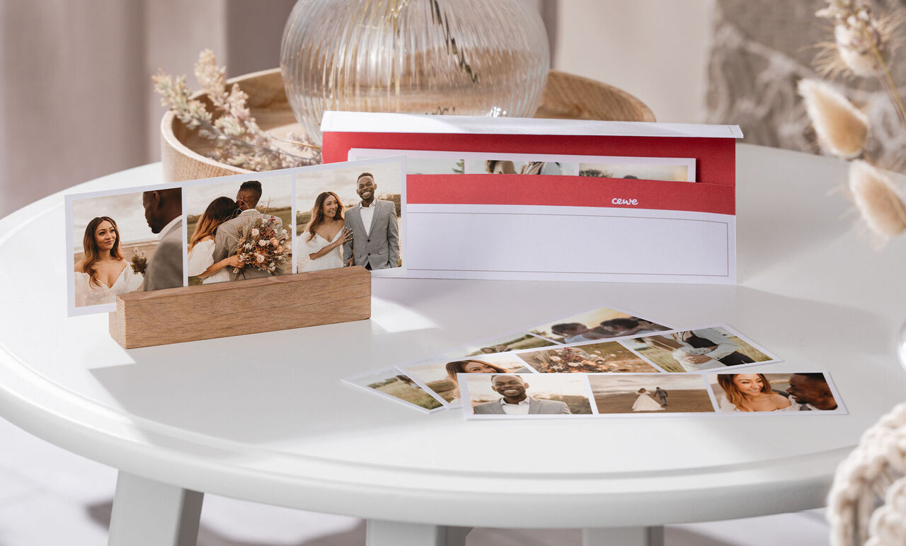 A stylishly presented CEWE photo calendar on a table with photos of a wedding and romantic moments.