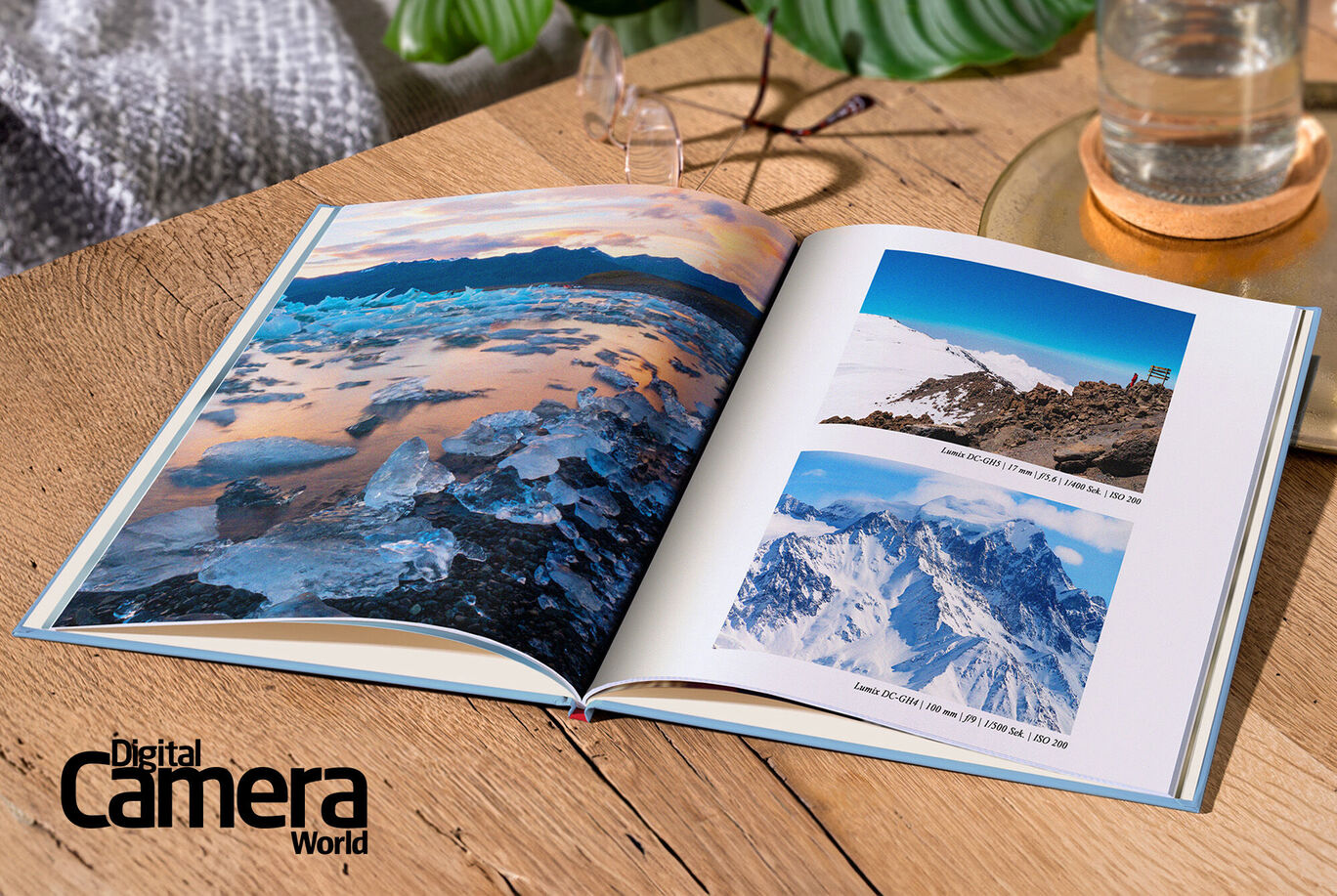 An open photo book on a wooden table. The pages feature beautiful landscapes of glaciers and mountains. A sensitive design with soft colors.