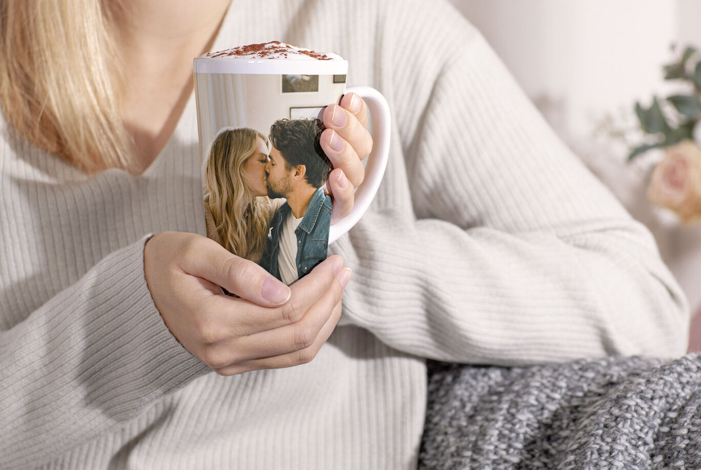 A person holds a cup with a personal photo in their hand.