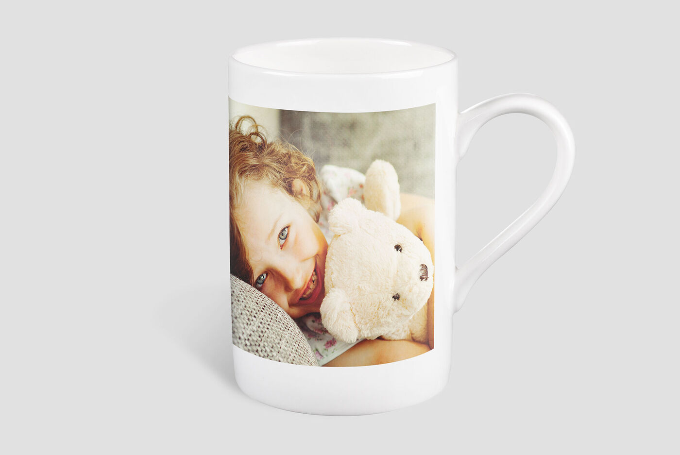Mug with a photo of a child and a teddy bear.