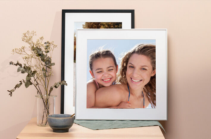 A lovingly designed framed photo of two people smiling joyfully at each other.