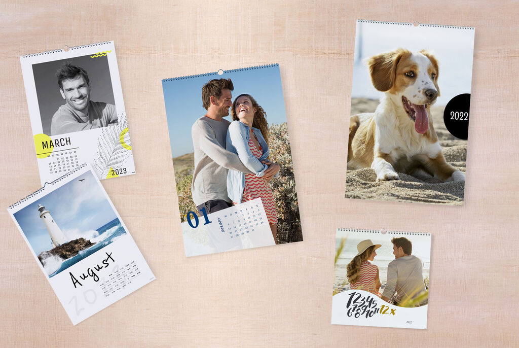 A creative photo calendar with various pictures from 2023 and 2022. The photos show beautiful moments, including a dog on the beach, a couple hugging, and a lighthouse shot. Each month is clearly displayed.