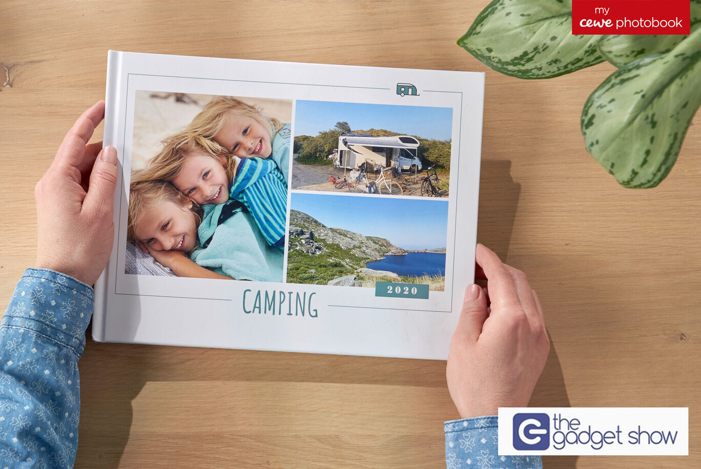 Two children hold a CEWE FOTOBUCH with camping themes.