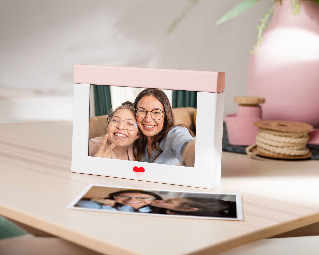 Photo of a frame with an image of two people having fun together, with a table of more memory pieces