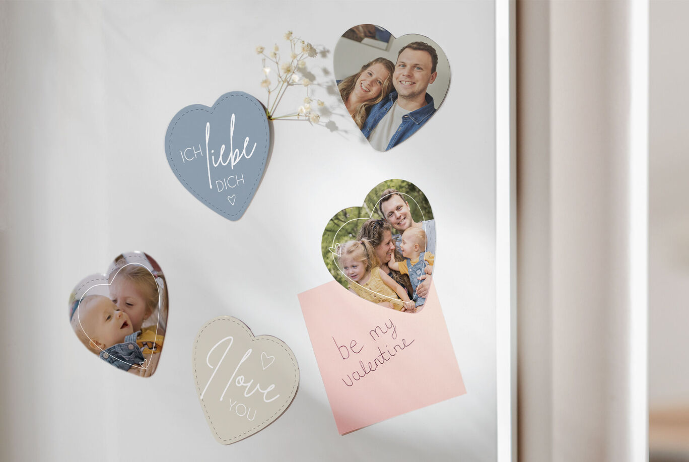 Colorful heart magnets with photos and notes on a wall.