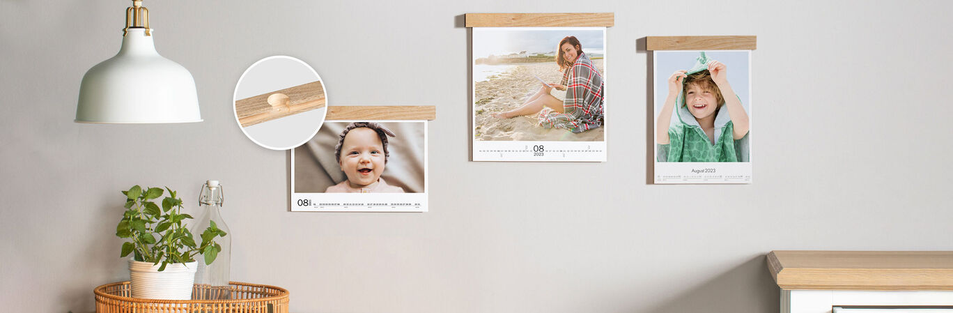 Three beautiful posters with wooden frames on a wall, plants and a lamp can be seen in the room.