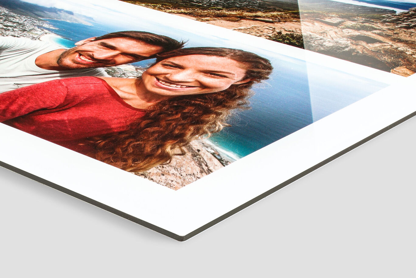 A couple holds a CEWE photo book with vacation memories.