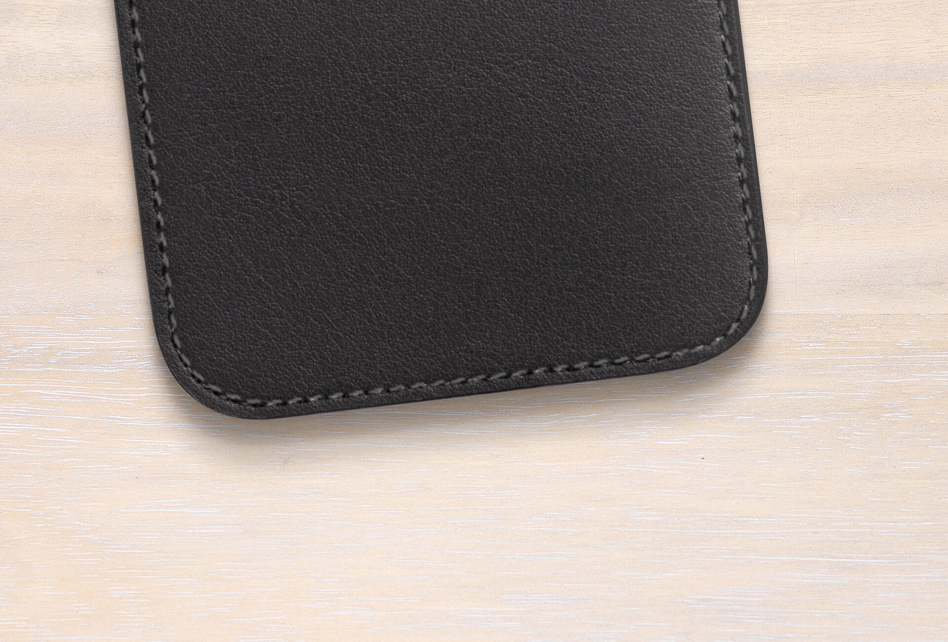 High-quality black leather case on a light wooden surface.