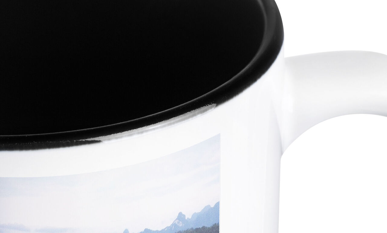 Close-up of a white mug with a landscape picture
