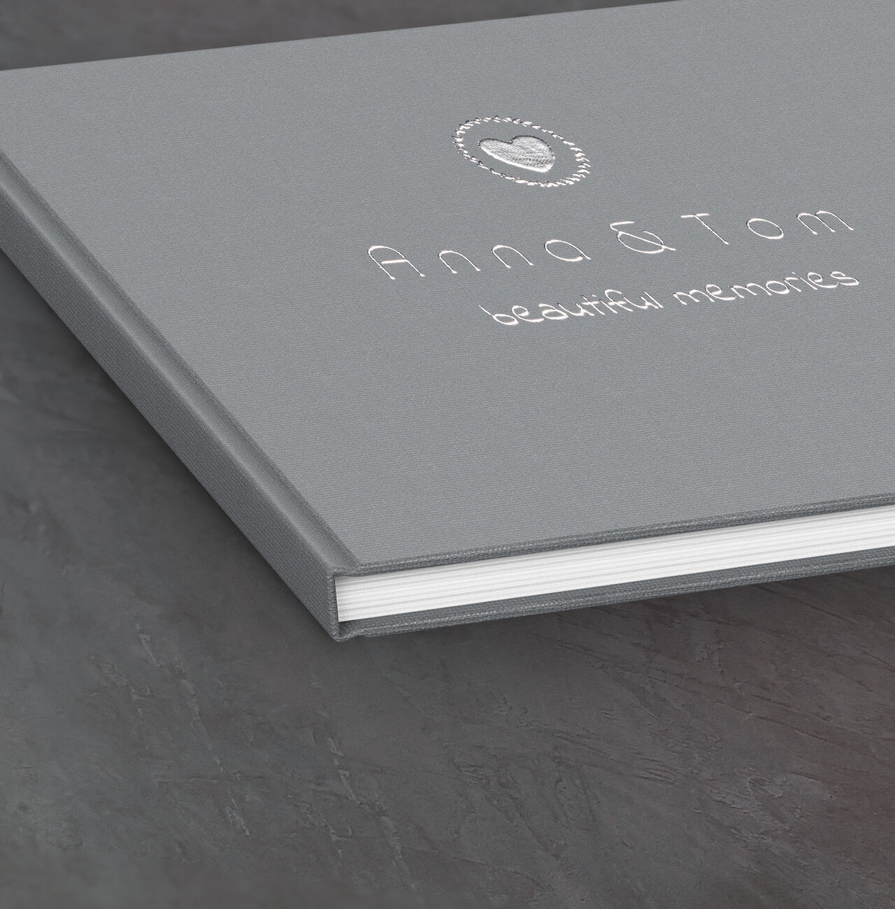 A gray photo book titled 'Anna & Tom - beautiful memories' on a decorative background.