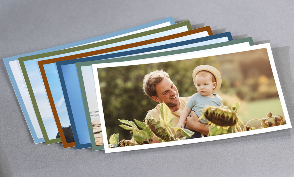 A loving snapshot showing a father with his child in nature, surrounded by green plants. Faces are blurry.