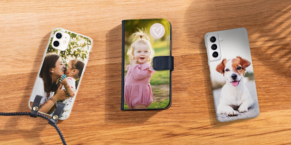 Three personalized phone cases on a table, one with a photo of a mother and her child, one with a cute dog, and one with a plush toy in a green background
