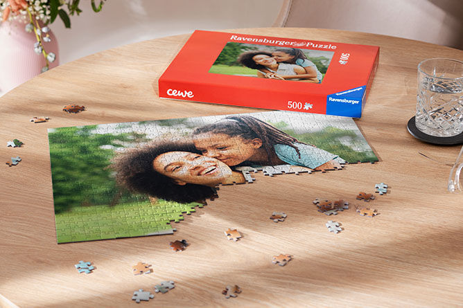 Puzzle with a happy mother and daughter on a table, next to the packaging.