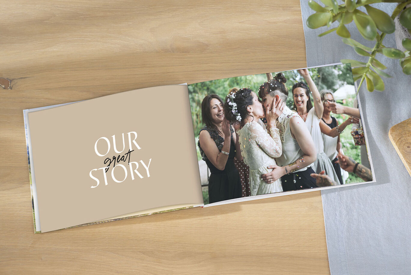 Two women kiss in the CEWE PHOTO BOOK, surrounded by happy guests celebrating the moment.