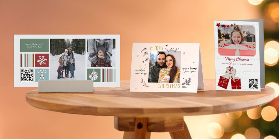 Three beautifully designed CEWE greeting cards on a table, fitting for Christmas, in various designs