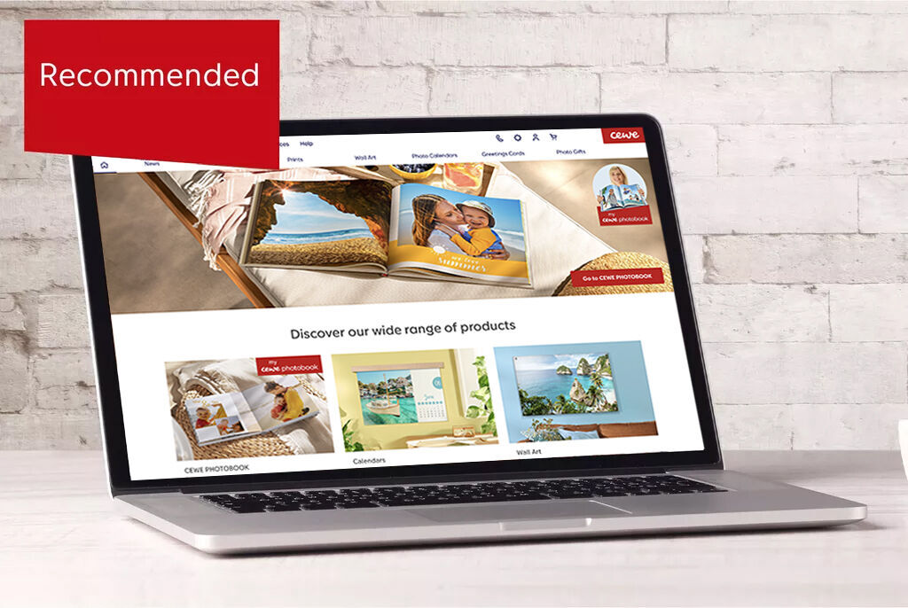 Laptop showing CEWE photo book and product recommendations on a website
