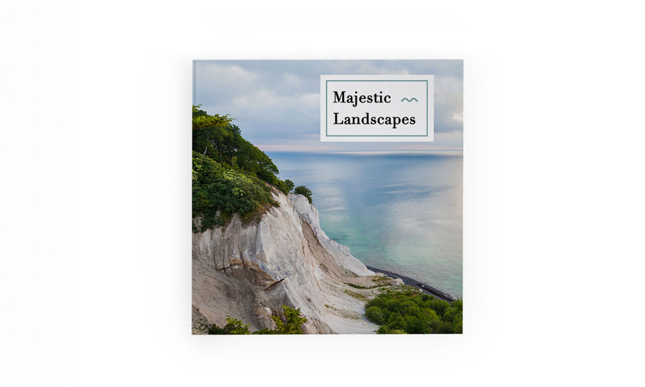 A stunning photo book titled 'Majestic Landscapes'. It showcases a breathtaking landscape with cliffs and a calm sea.
