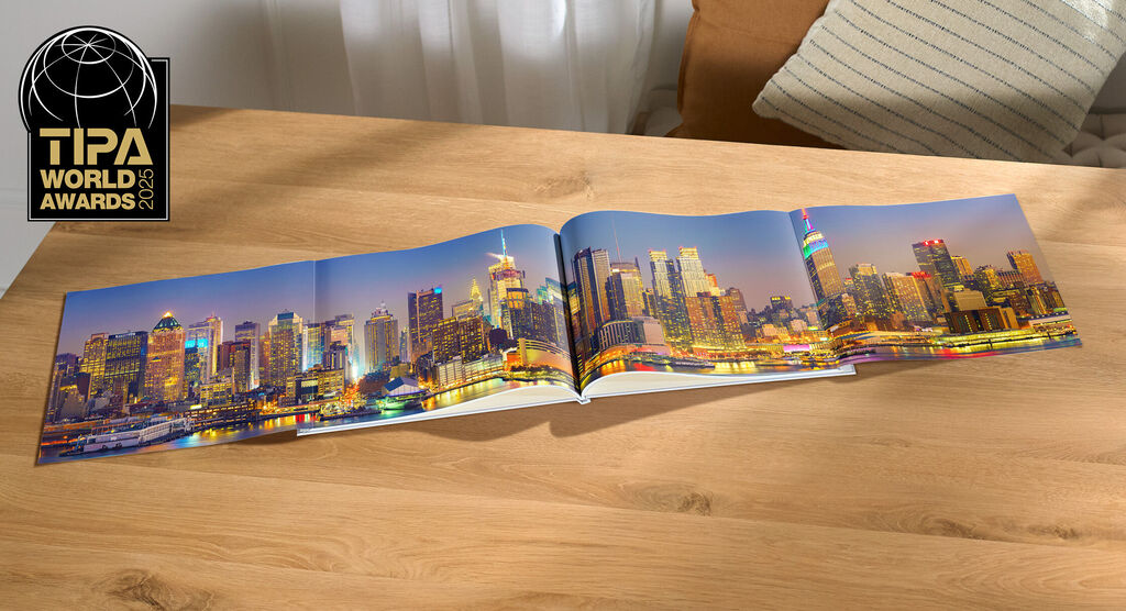 CEWE photo book with stunning skyline image of a city at night on a table