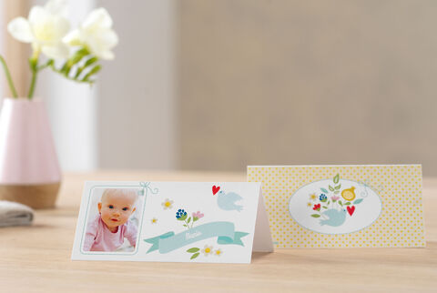 Two lovingly designed greeting cards on a table, one with floral motifs and a photo, the other in soft colors with bird motifs.