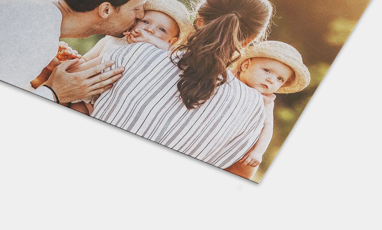 A family hugs two children outdoors, joyful atmosphere, summer clothing