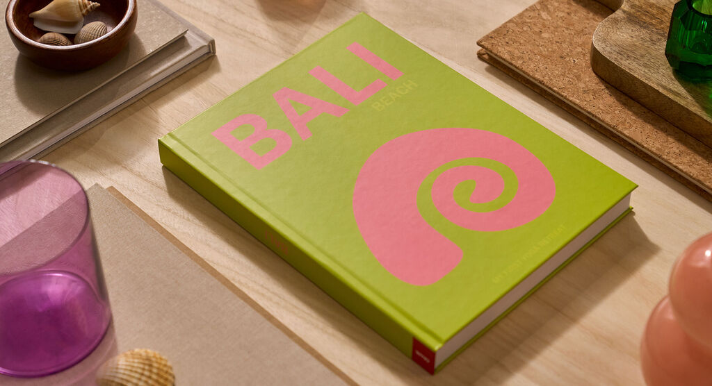 A Bali-themed coffee table book laying on a wooden table.