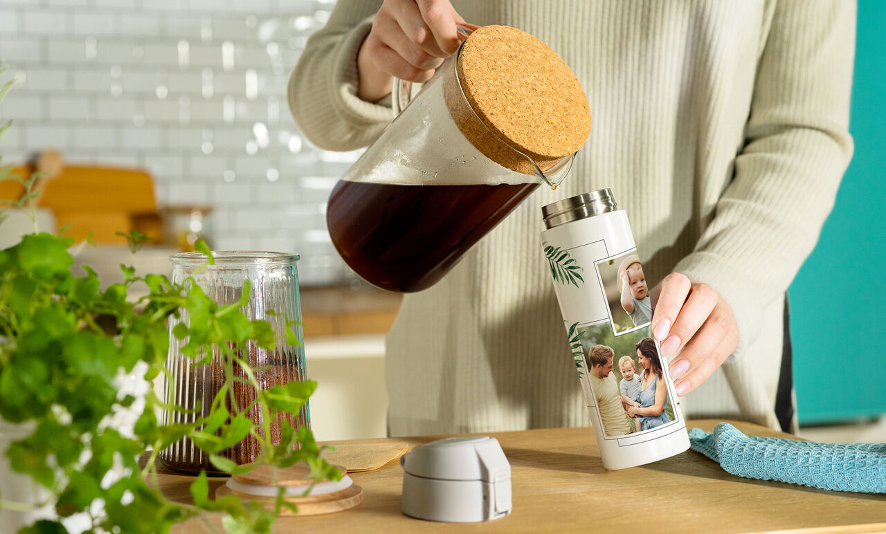 A person pours coffee from a pot into a personalized thermos with photos.