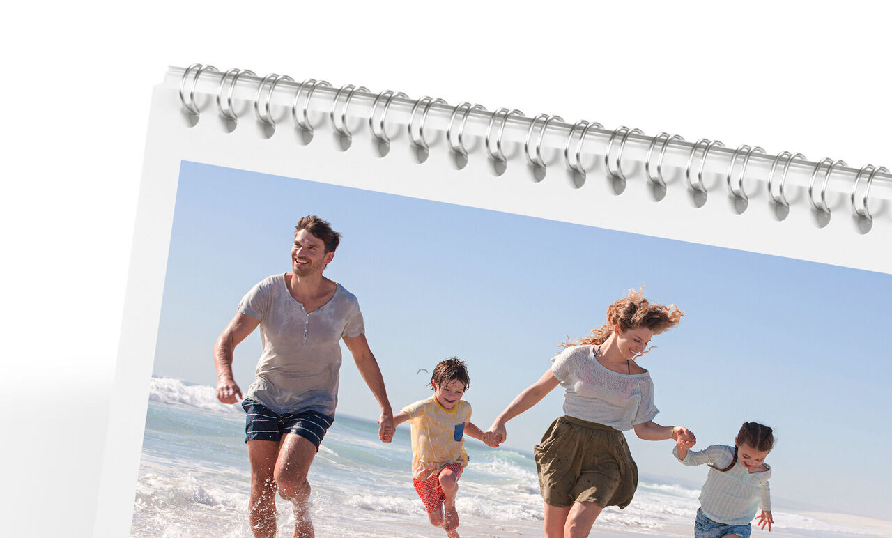Family happily walking along the beach enjoying the sun. CEWE photo calendar.