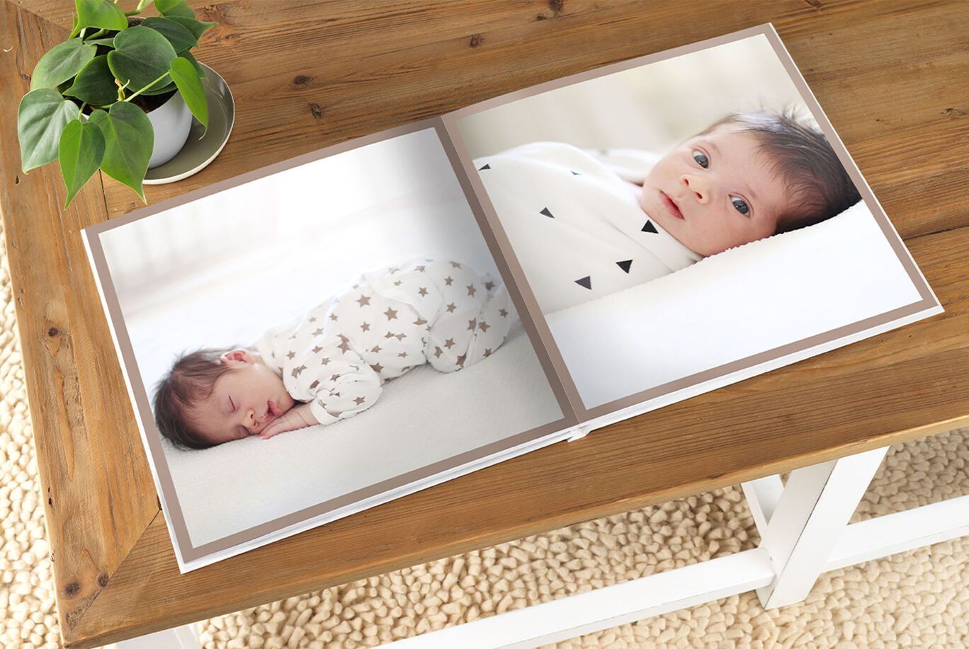 Two sides of a photo book showing a sleeping baby in a cozy room and a plant on a table.