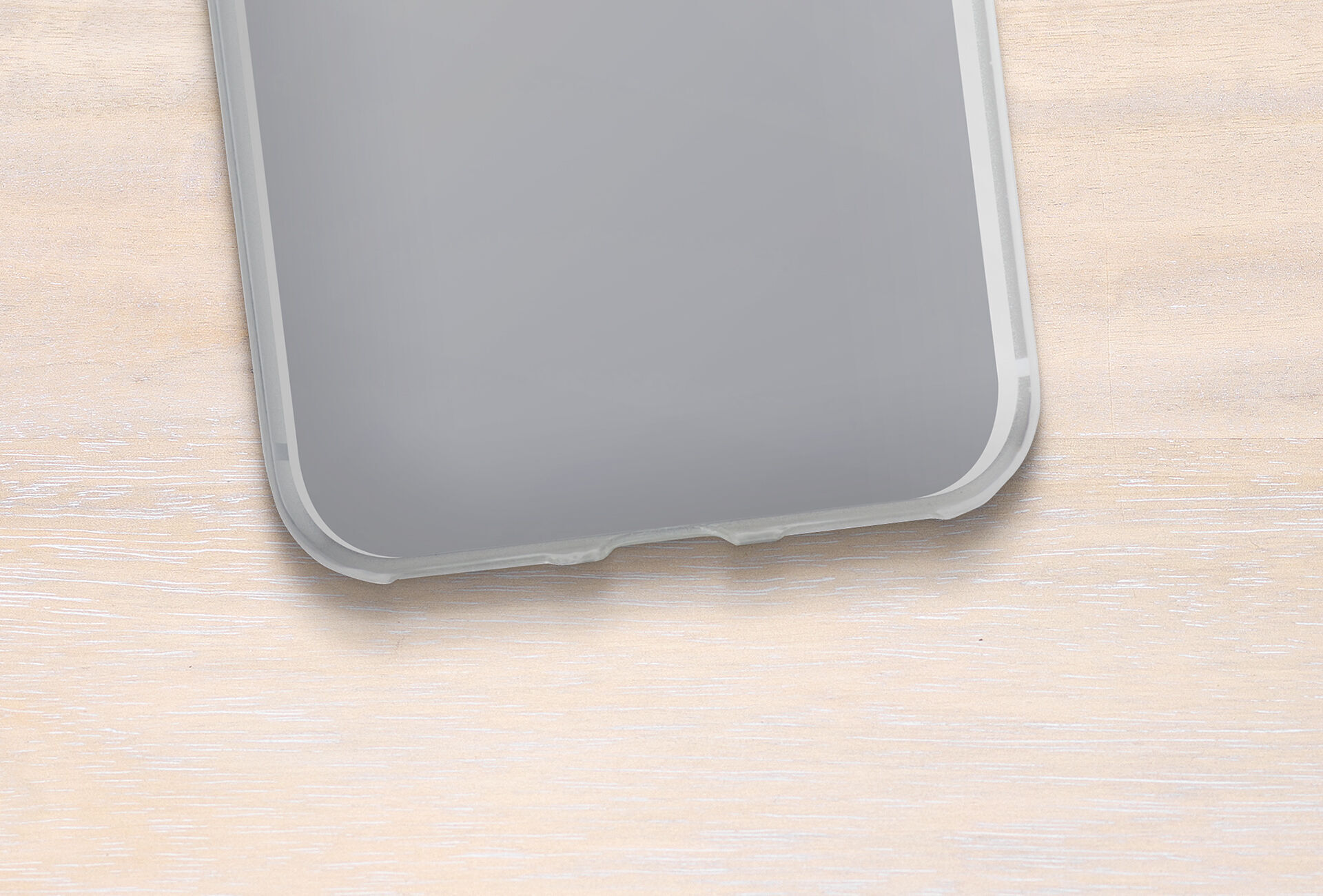 View of the corner of a smartphone on a light wooden surface