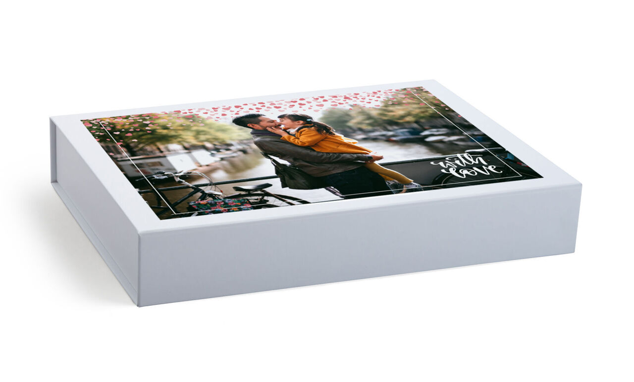 A lovely, personalized photo book in a romantic package featuring a couple on the cover. A cozy couple embraces among heartfelt floral motifs.