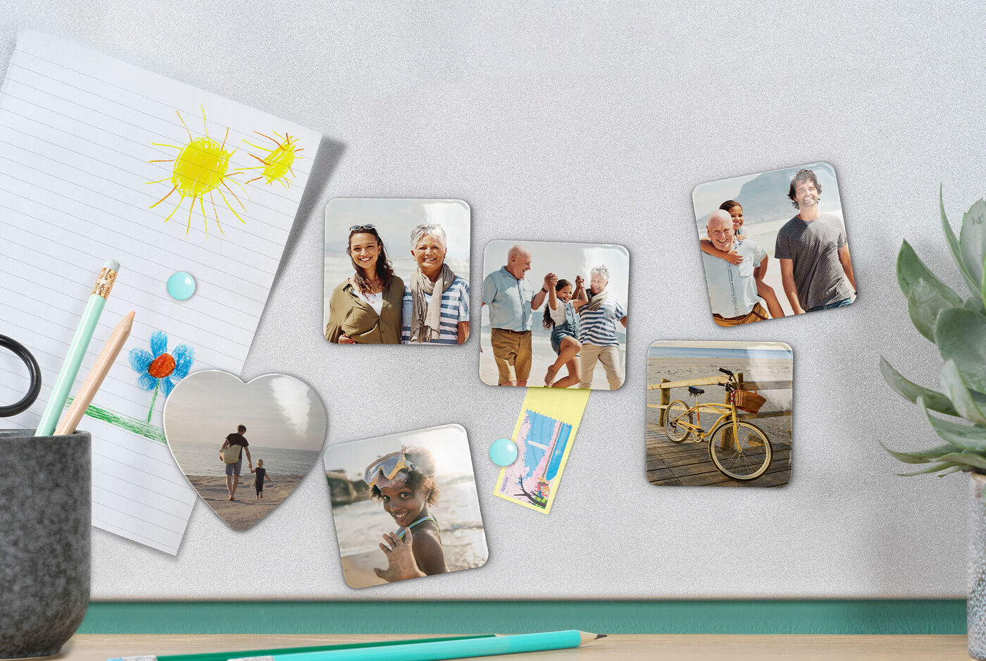 A colorful arrangement of photos in different shapes hanging on a gray wall. There are pictures of happy people, a bike ride, and a child on the beach.