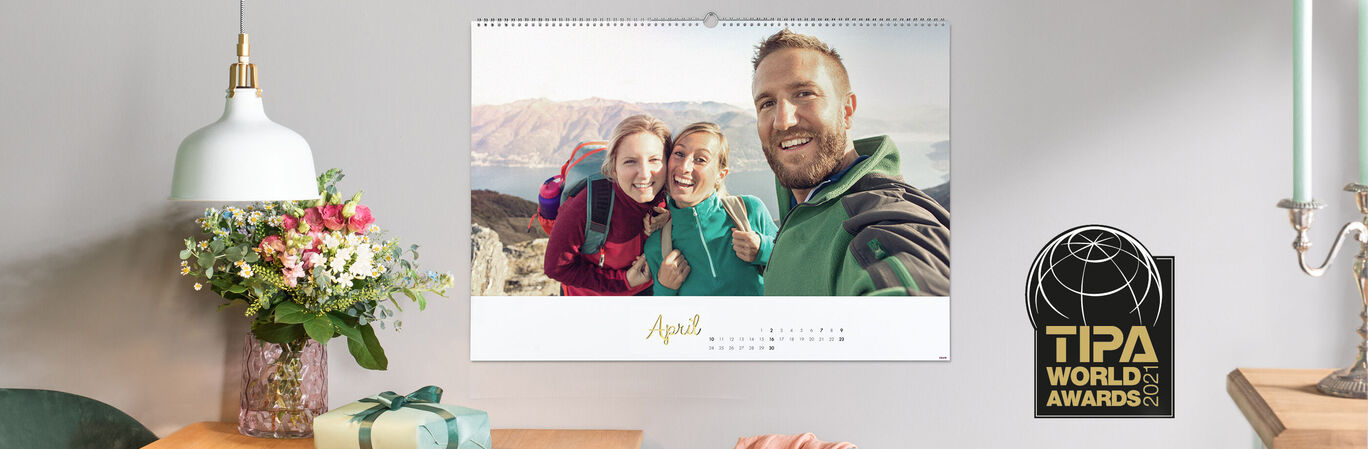 Family enjoying a lovely time with a photo calendar on a table, surrounded by flowers and decorations.