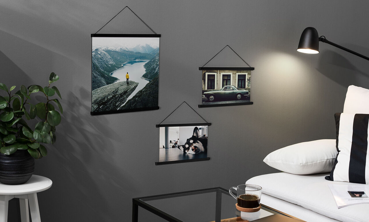 Wall pictures with natural motifs and a person on a mountain, decorating a living space.