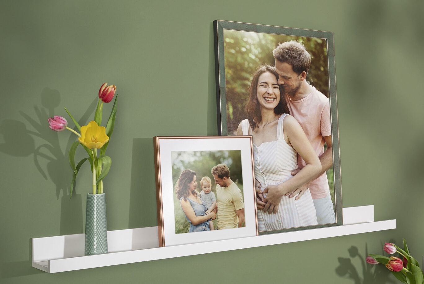 Family photos in elegant frames on a shelf, surrounded by fresh flowers