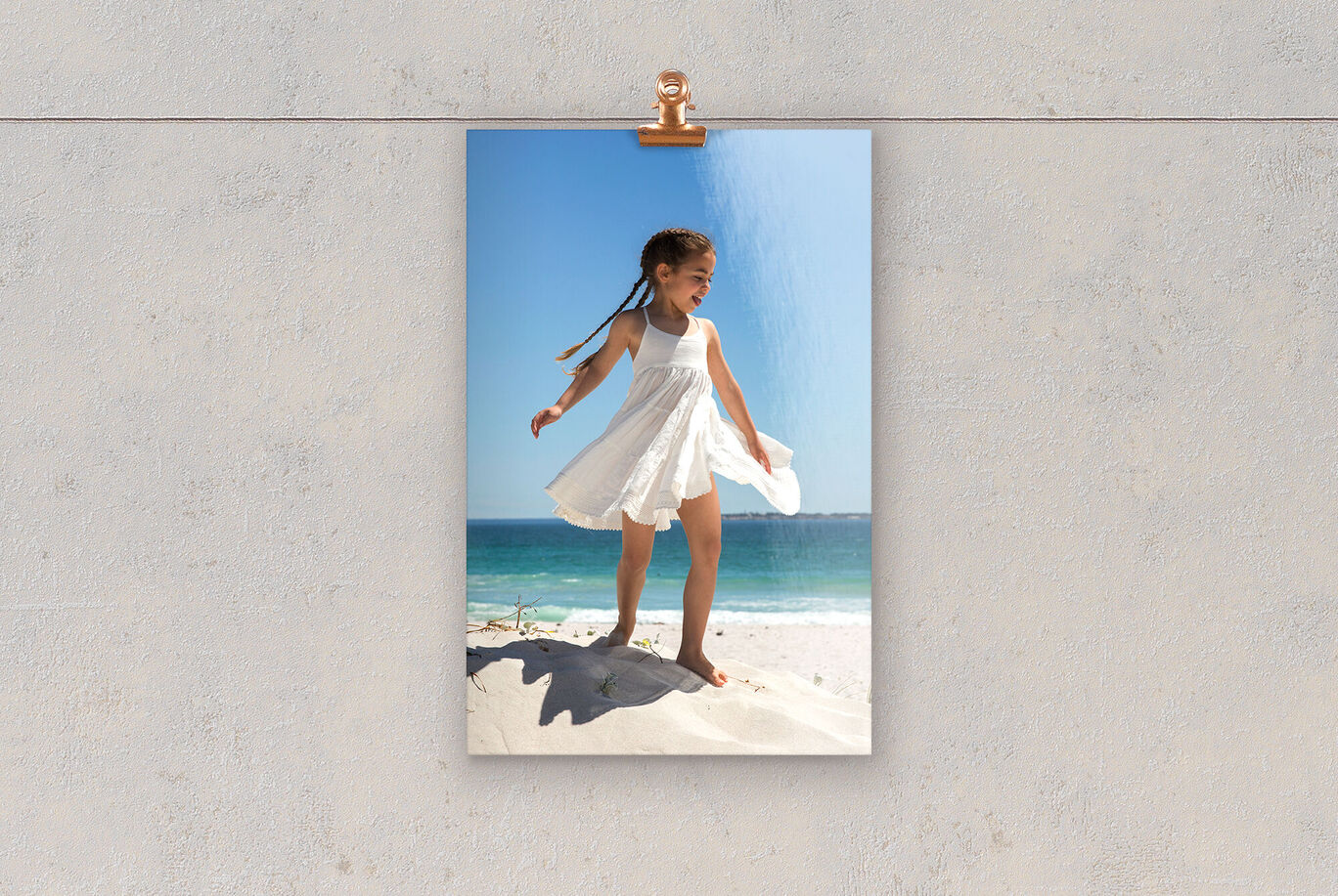 Playing girls in white dresses on a sandy beach.